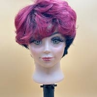 A mannequin head with pink hair and blue eyes.